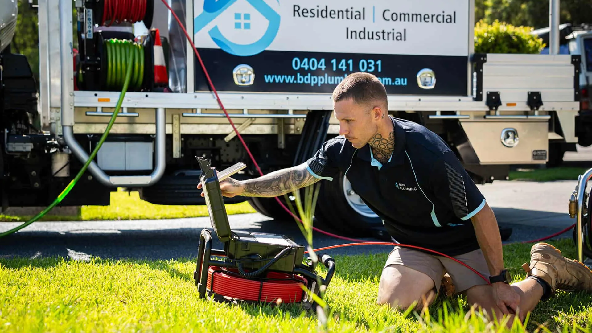 Plumber running a CCTV drain camera beside the truck